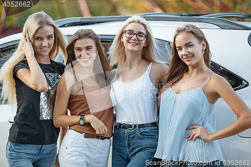 Image of The young women standing near the car