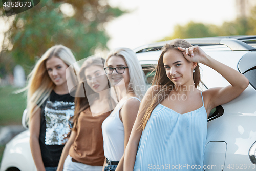 Image of The young women standing near the car