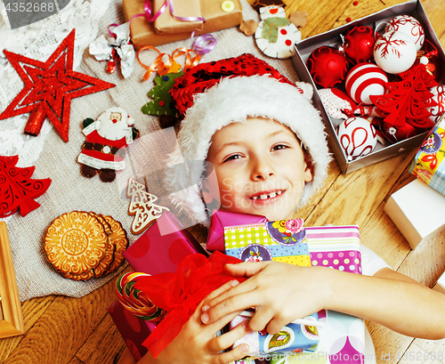 Image of little cute boy with Christmas gifts at home. close up emotional