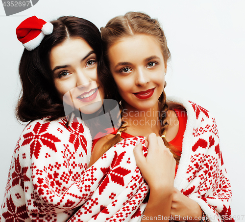 Image of young pretty happy smiling blond and brunette woman girlfriends on christmas in santas red hat and holiday decorated plaid, lifestyle people concept 