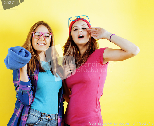 Image of lifestyle people concept: two pretty young school teenage girls having fun happy smiling on yellow background 