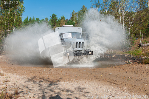 Image of truck passes through a puddle