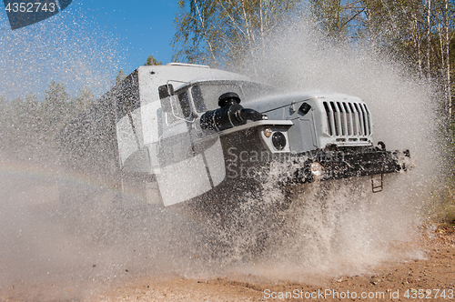 Image of truck passes through a puddle