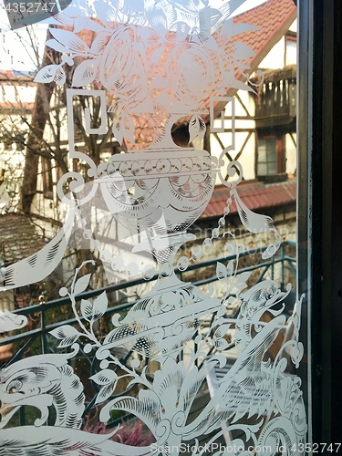 Image of Ancient half-timbered house as seen through a richly decorated window