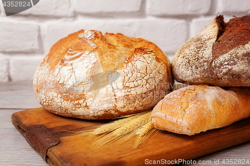 Image of Fresh homemade bread assortment on old cutting board