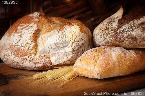 Image of Fresh homemade bread assortment on old cutting board