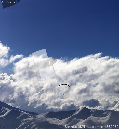 Image of Winter mountain in evening and sunlight silhouette of parachutis