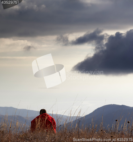 Image of Man resting at mountains in evening