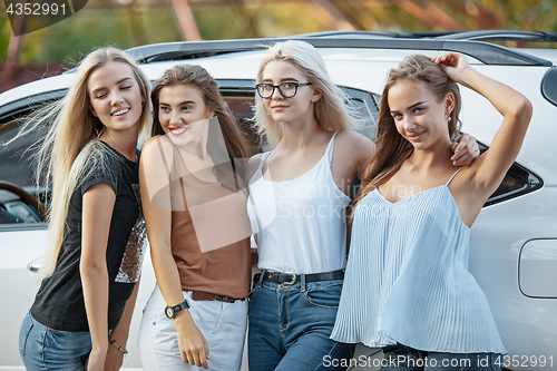 Image of The young women standing near the car