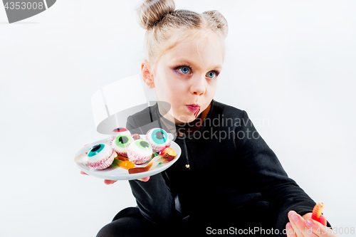 Image of Little girl witch in black dress over magical accessories. Halloween, the studio evening.