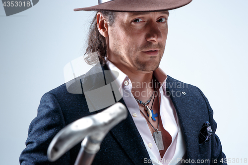 Image of Young man portrait with hat on gray studio background.