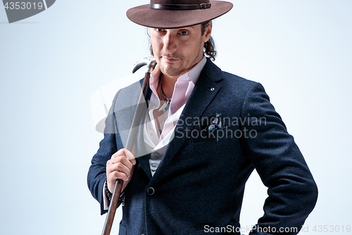 Image of Young man portrait with hat on gray studio background.