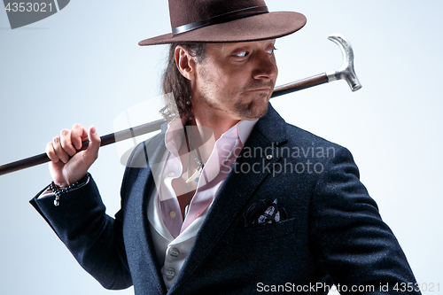 Image of Young man portrait with hat on gray studio background.