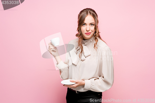 Image of The serious frustrated young beautiful business woman on pink background