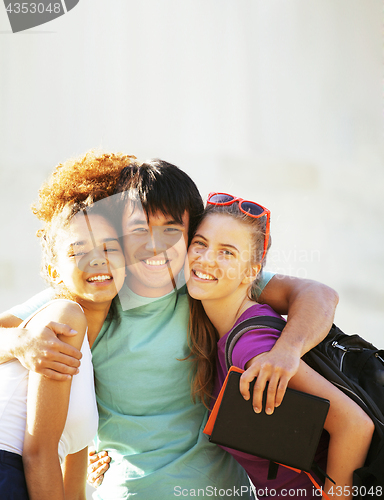 Image of cute group of teenages at the building of university with books huggings, back to school