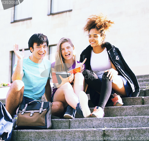 Image of cute group of teenages at the building  university with books huggings, back to school
