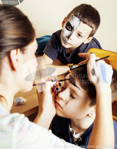 Image of little cute child making facepaint on birthday party, zombie Apo
