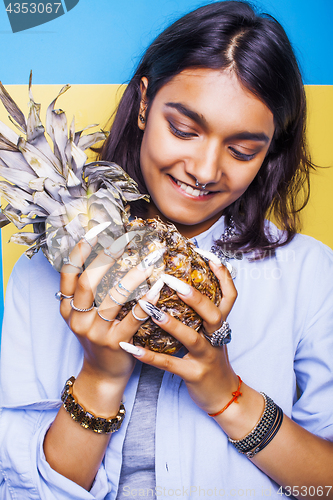 Image of lifestyle people concept. young pretty smiling indian girl with pineapple, asian summer fruits 