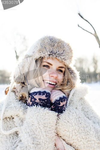 Image of young pretty teenage hipster girl outdoor in winter snow park having fun drinking coffee, warming up happy smiling, lifestyle people concept