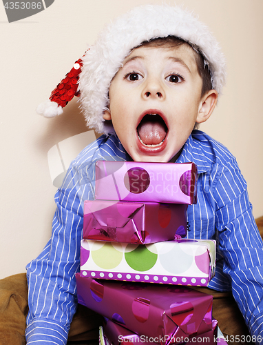 Image of little cute boy with Christmas gifts at home. close up emotional