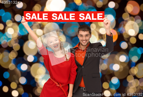 Image of couple with red sale sign over christmas lights