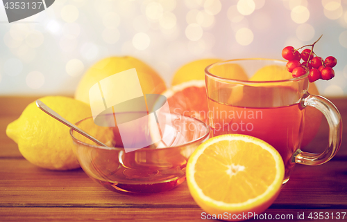 Image of tea with honey, lemon and rowanberry on wood