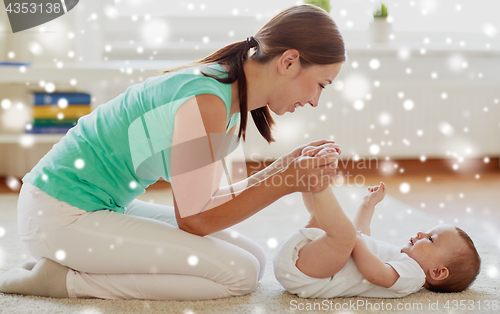 Image of happy mother playing with little baby at home