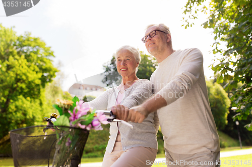 Image of happy senior couple with bicycles at summer park