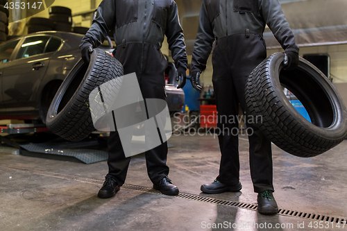 Image of auto mechanics changing car tires at workshop