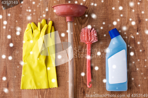 Image of plunger with toilet cleaning stuff on wood