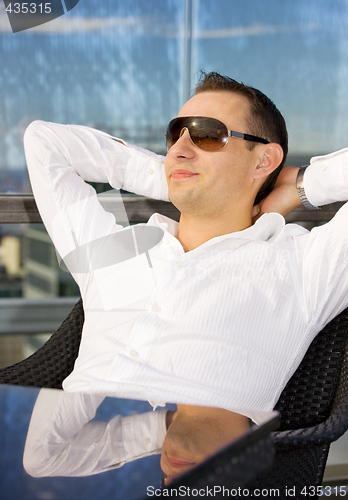 Image of handsome man relaxing in chair