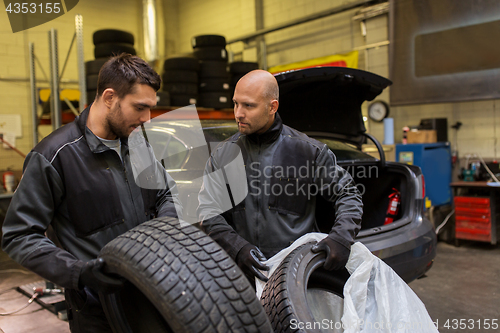 Image of auto mechanics changing car tires at workshop