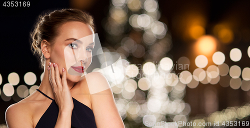 Image of beautiful woman over christmas tree lights