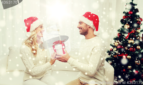 Image of happy couple at home with christmas gift box
