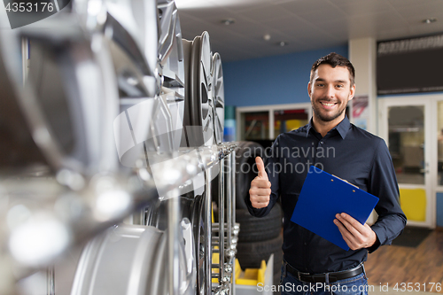 Image of auto business owner and wheel rims at car service