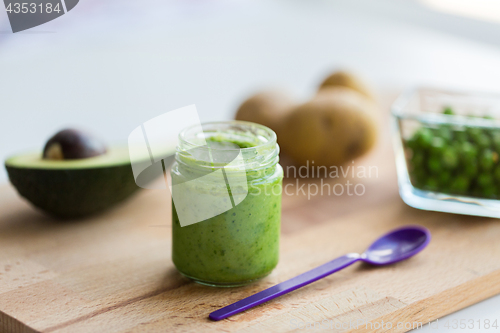 Image of jar with puree or baby food on wooden board