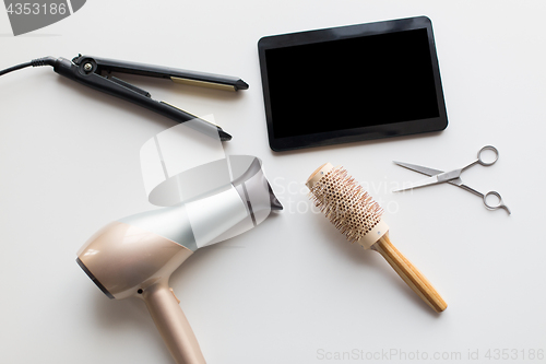 Image of tablet pc, scissors, hairdryer, hot iron and brush