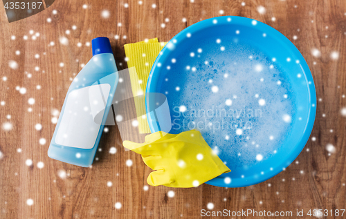 Image of basin with cleaning stuff on wooden background