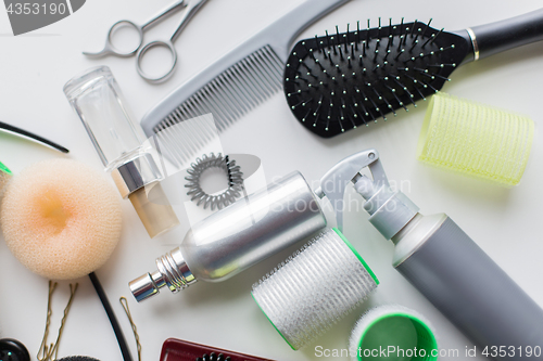 Image of hair brush, styling sprays, curlers and pins