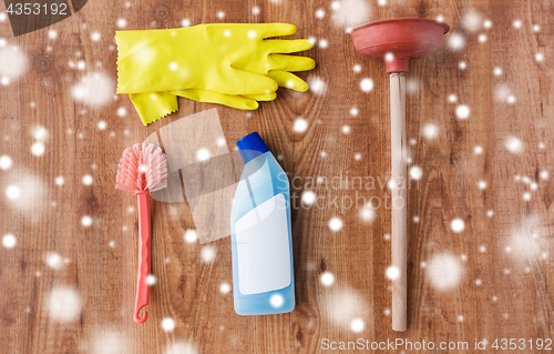 Image of plunger with toilet cleaning stuff on wood