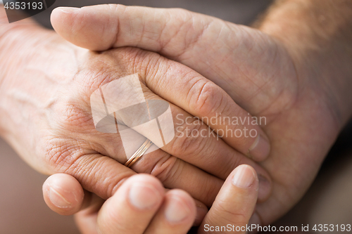 Image of close up of senior couple holding hands