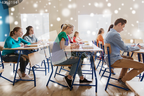 Image of group of students with books writing school test