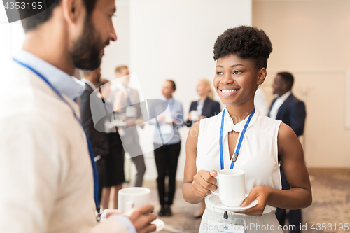 Image of business people with conference badges and coffee