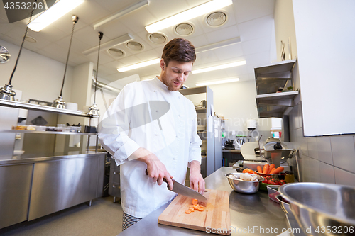 Image of happy male chef cooking food at restaurant kitchen