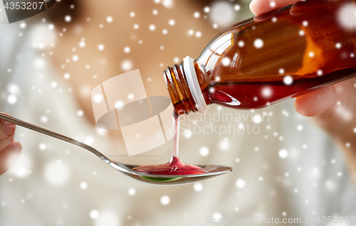 Image of woman pouring medication from bottle to spoon