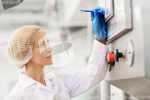 Image of woman programming computer at ice cream factory