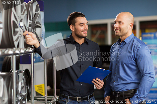 Image of customer and salesman at car service or auto store