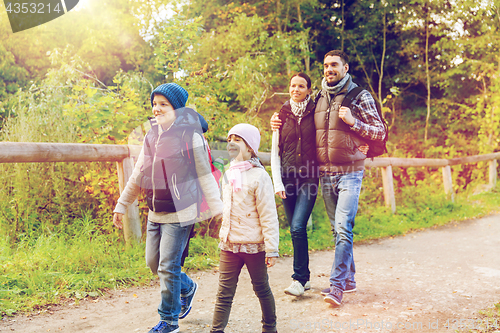 Image of happy family with backpacks hiking in woods