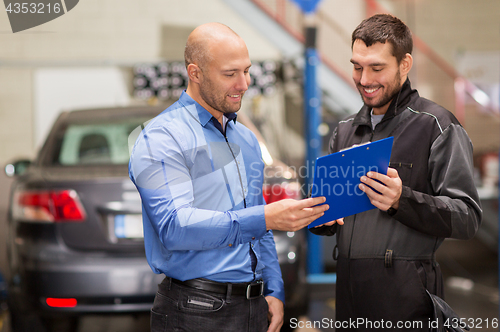 Image of auto mechanic and customer at car shop