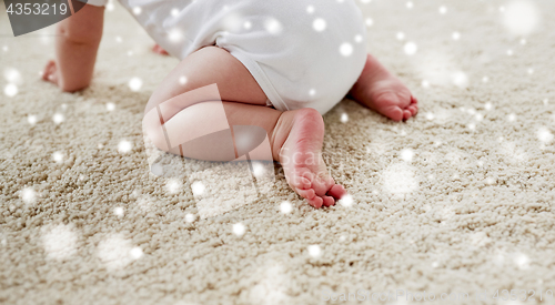 Image of little baby in diaper crawling on floor